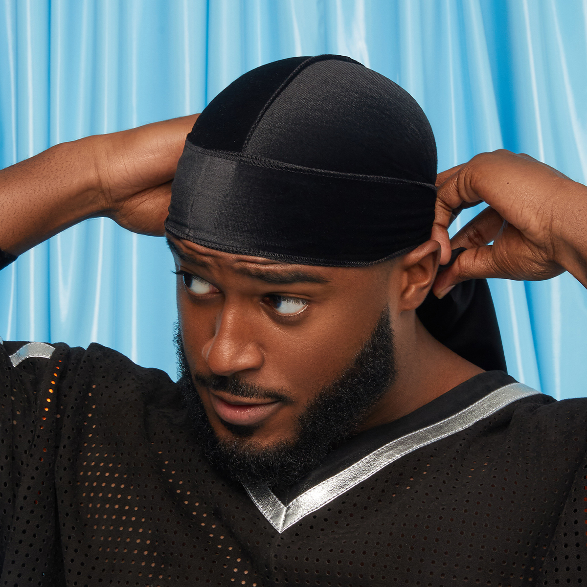 A man modeling the Bow Wow KISS Colors and Care Power Wave Luxe Velvet Durag in Black.
